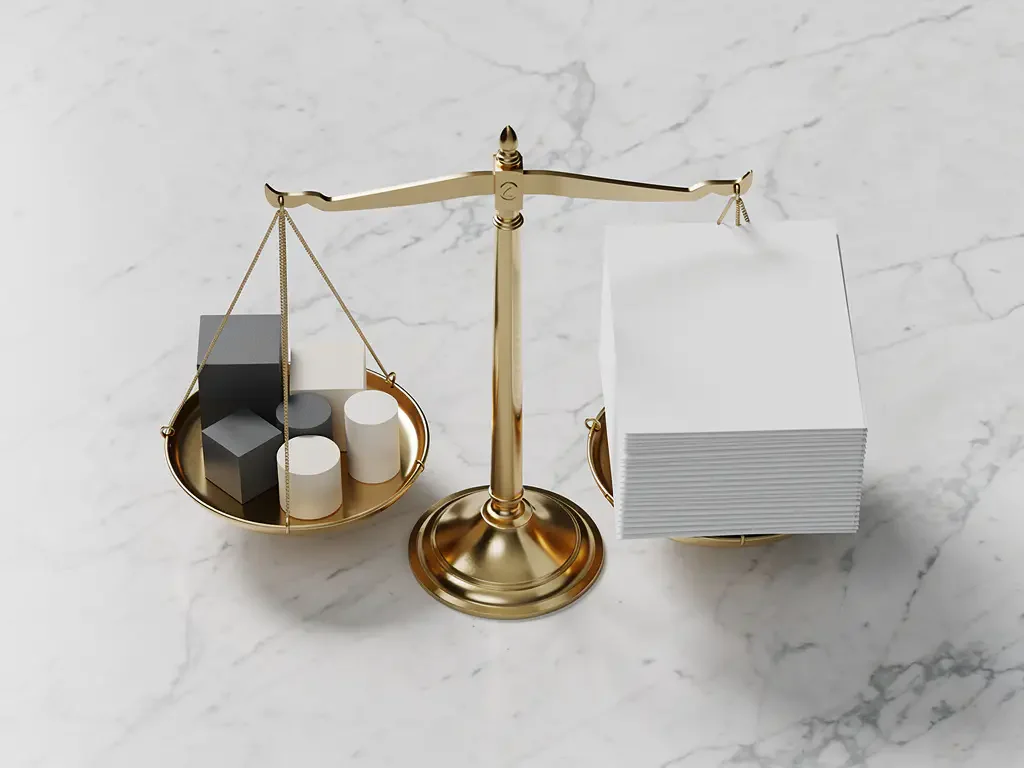Brass scale with geometric business blocks and white financial documents on marble surface