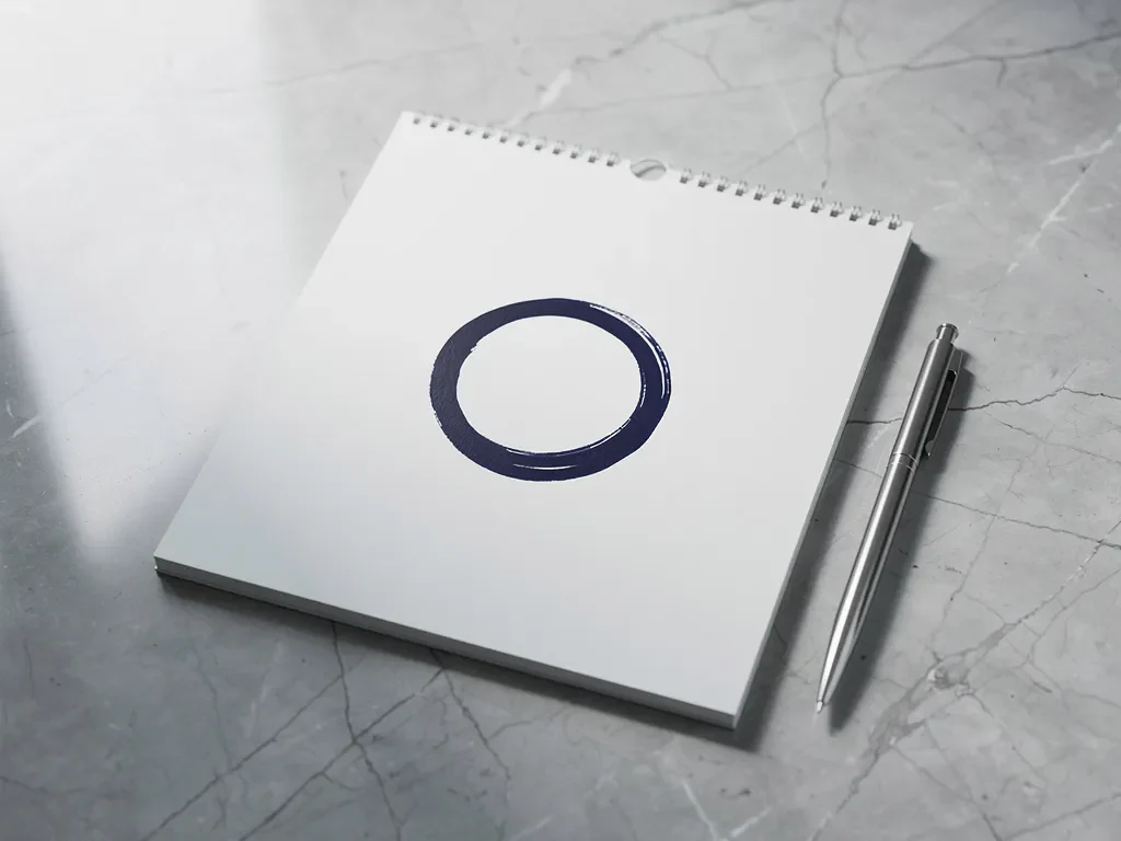 Witte kalender met marineblauw omcirkelde datum op marmeren bureau met zilveren pen, natuurlijk licht